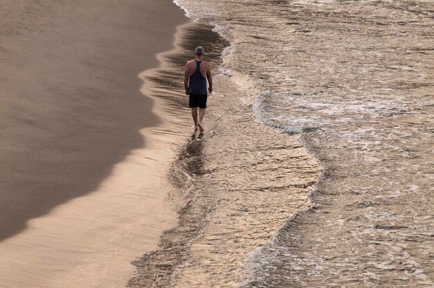 Foto achtergrond van een man die op het strand loopt