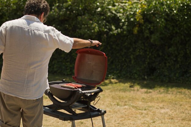 Foto achtergrond van een man die worstjes barbecueert