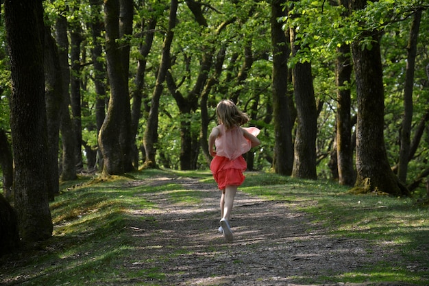 Achtergrond van een meisje dat op een voetpad in het bos loopt