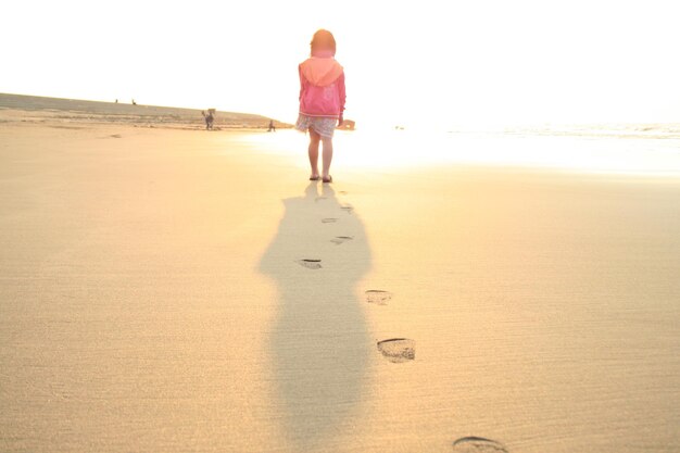 Foto achtergrond van een meisje dat op het strand loopt