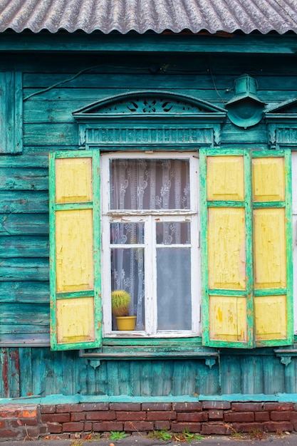 Achtergrond van een oud raam met houten luiken Muur van een houten huis met een raam