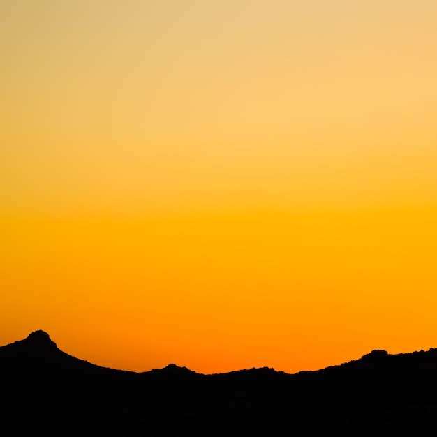 Achtergrond van een prachtige kleurrijke zonsondergang met het silhouet van de bergen. Hoge kwaliteit foto