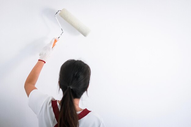 Achtergrond van een vrouw die aan de muur schildert.