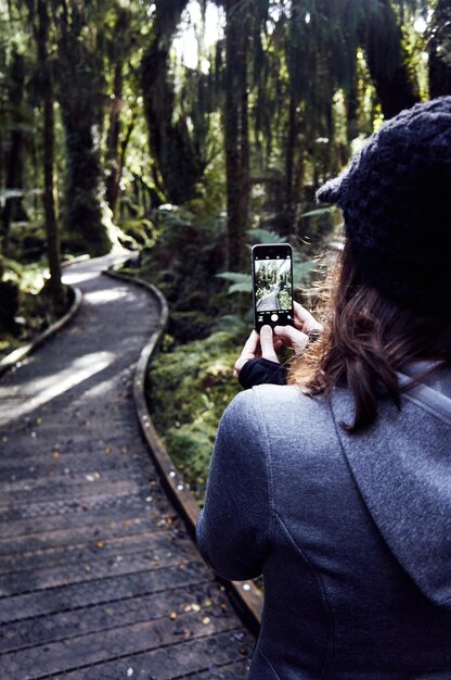 Foto achtergrond van een vrouw die in het bos staat