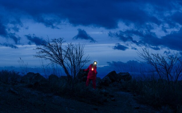 Foto achtergrond van een vrouw die op de berg tegen de hemel staat