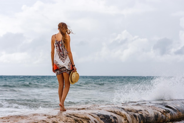 Achtergrond van een vrouw die op een pier langs de zee loopt