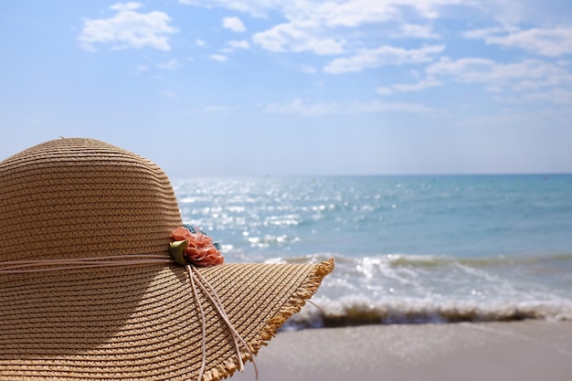Achtergrond van een vrouw met een hoed op het strand tegen de lucht