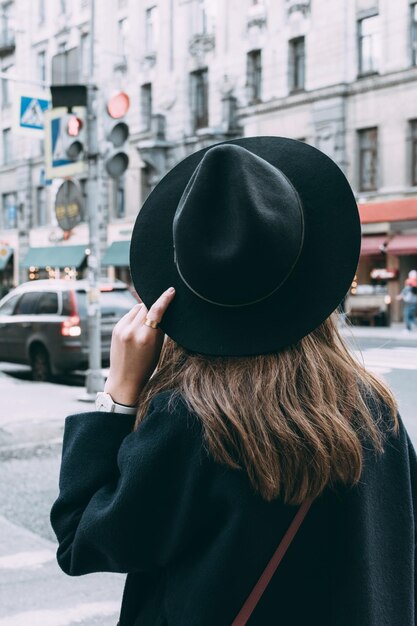 Achtergrond van een vrouw met een hoed terwijl ze op straat staat