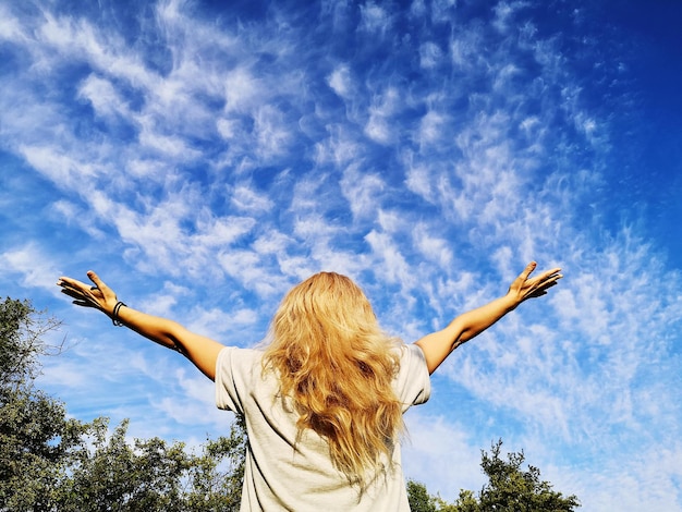 Foto achtergrond van een vrouw met haar armen tegen de lucht opgeheven