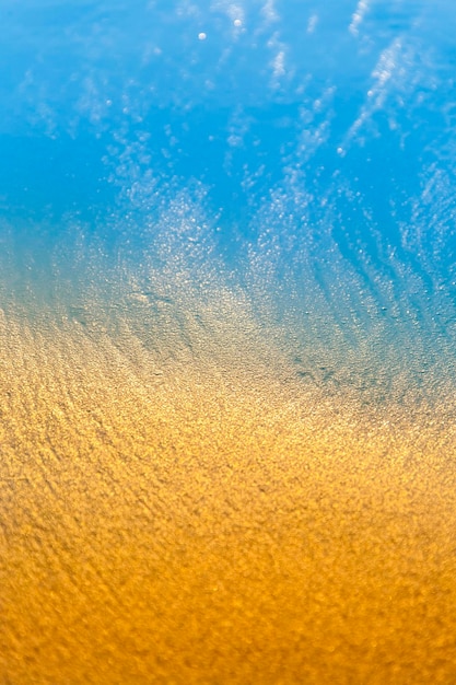 Achtergrond van goud zand en blauwe golf