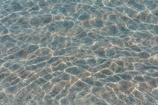 Achtergrond van het wateroppervlak van de rode zee en de zandbodem