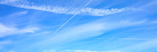 Achtergrond van mooie heldere blauwe daghemel met witte wolk en spoor van het vliegtuig. banner