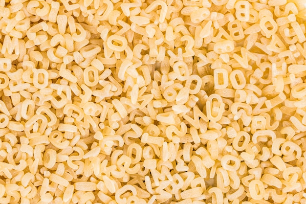 Achtergrond van rauwe pasta in de vorm van letters en cijfers