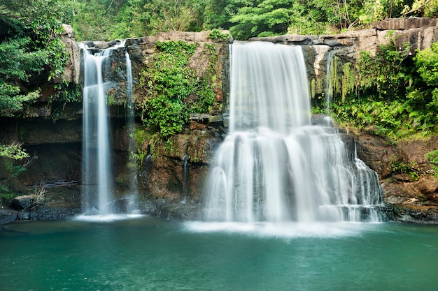 Achtergrond van stromende waterval in nationaal park in diepe boswildernis op berg.