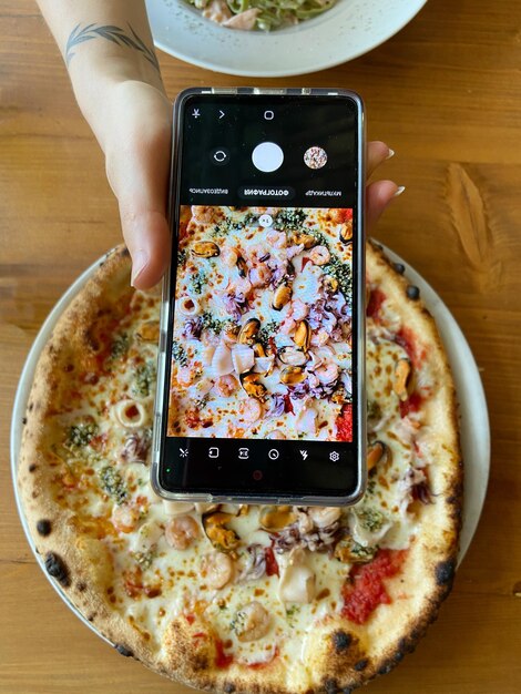 Achtergrond van vegetarische pizza met tomaten, kaas, kruiden, zeevruchten close-up. Bovenaanzicht, plat gelegd