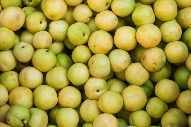 Achtergrond van verse groene pruimen op de markt.