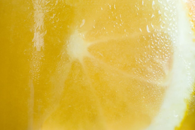 Achtergrond van verse koude citruscocktail Close-up foto van glazen wand van fruitdrank met druppels water en gesneden oranje vorm verfrissing en koelte concept