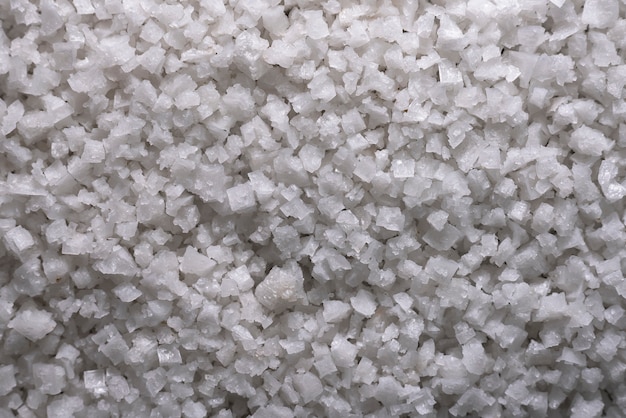 Achtergrond van zeezout, korrels van de productie van zoutkristallen. Hoop grof zout