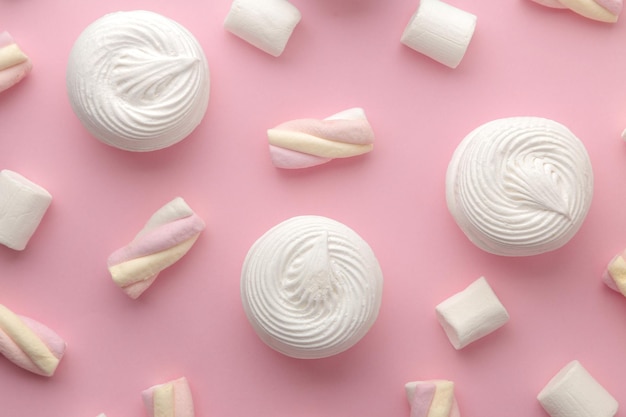 Achtergrond van zoete witte marshmallows en kleine marshmallows op heldere trendy roze achtergrond Sweets dessert weergave van bovenaf
