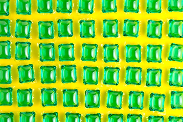 Foto achtergrond veel capsules voor groen wassen op gele achtergrond