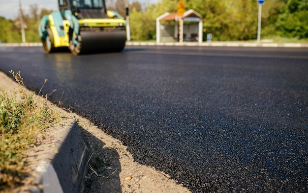 Foto achtergrond vervagen rollen rollen vers heet asfalt op de nieuwe weg wegenbouw