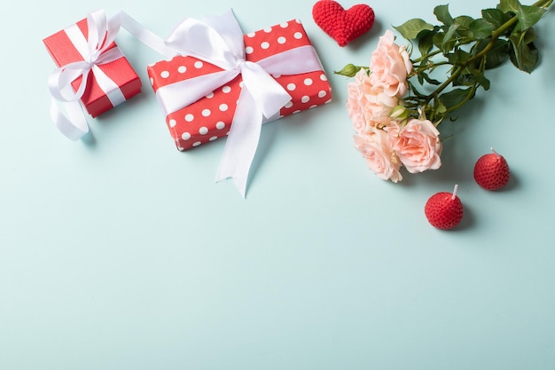 Achtergrond voor de Valentijnsdag vakantie Rode geschenken en een boeket rozen op een lichtblauwe achtergrond