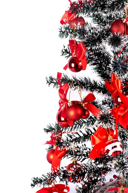 Achtergrond voor kerstkaart met close-up op rode kerstballen opknoping op takken van kunstmatige kerstboom portret witte achtergrond
