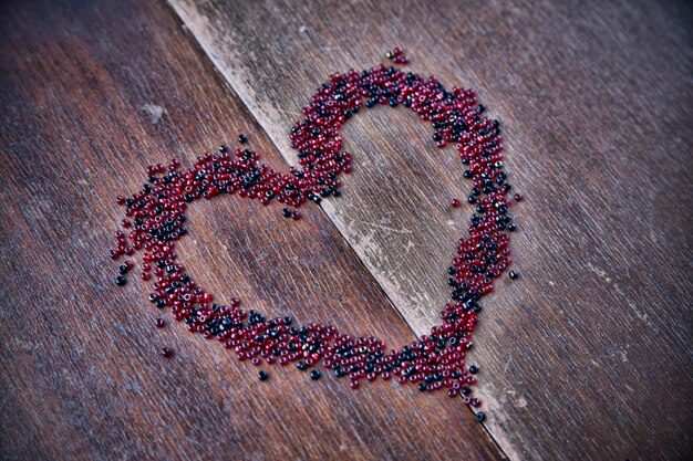 Achtergrond voor Valentijnsdag Hartvorm in een hoop kralen Ik hou van je Houten patroon