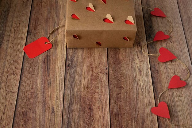 Achtergrond voor Valentijnsdag Slinger van harten cadeau van ambachtelijk papier op een houten achtergrond Valentine