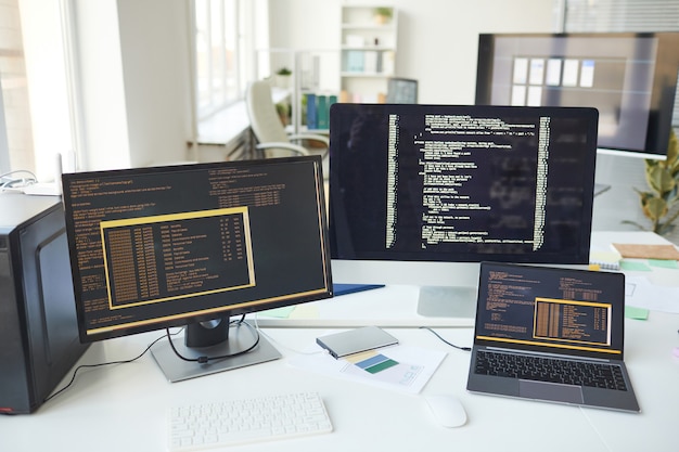 Achtergrondafbeelding van verschillende computerschermen met coderegels op het bureau in het kantoor van it-ontwikkelaars, kopieer ruimte