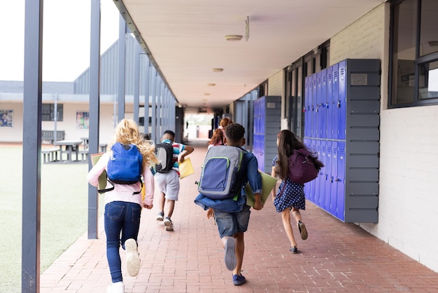 Achtergrondbeeld van diverse kinderen met schoolzakken die in de gang van de basisschool rennen.