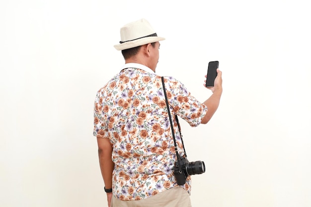 Foto achtergrondbeeld van een aziatische man die staat terwijl hij een mobiele telefoon vasthoudt, geïsoleerd op een witte achtergrond met copyspace