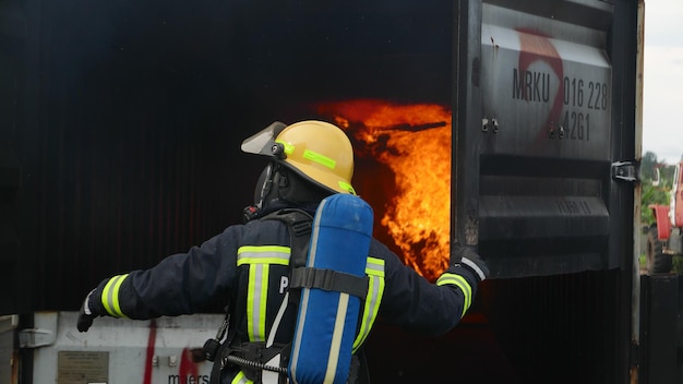 Foto achtergrondbeeld van een brandweerman bij een brandend gebouw