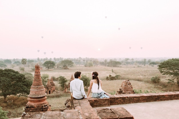 Achtergrondbeeld van een echtpaar dat op een tempel tegen de lucht zit