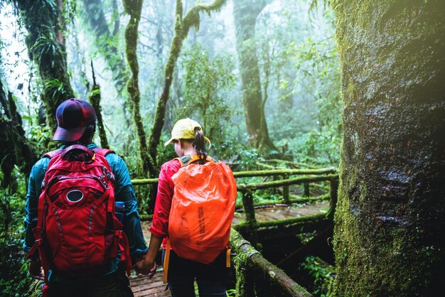 Achtergrondbeeld van een echtpaar met rugzakken dat in het bos wandelt