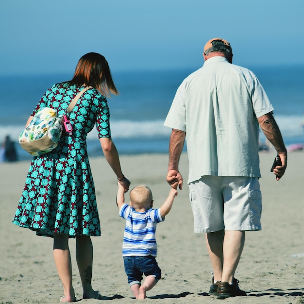 Achtergrondbeeld van een gezin dat op het strand wandelt