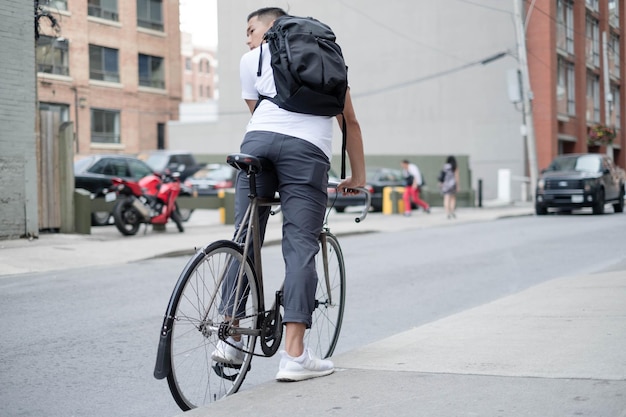 Achtergrondbeeld van een jonge man die op een fiets op straat in de stad rijdt