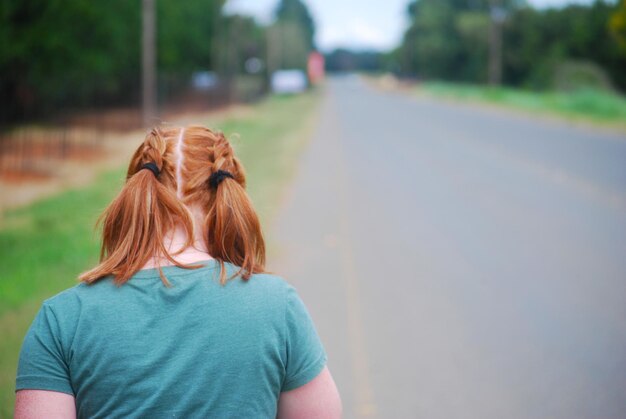 Foto achtergrondbeeld van een jonge vrouw die op de weg staat