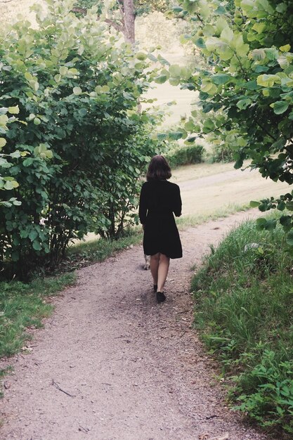 Foto achtergrondbeeld van een jonge vrouw die op het voetpad in het park loopt