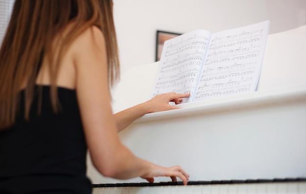 Foto achtergrondbeeld van een jonge vrouw die piano speelt