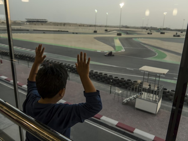 Foto achtergrondbeeld van een jongen die door het raam kijkt terwijl hij in het vertrekgebied van de luchthaven staat