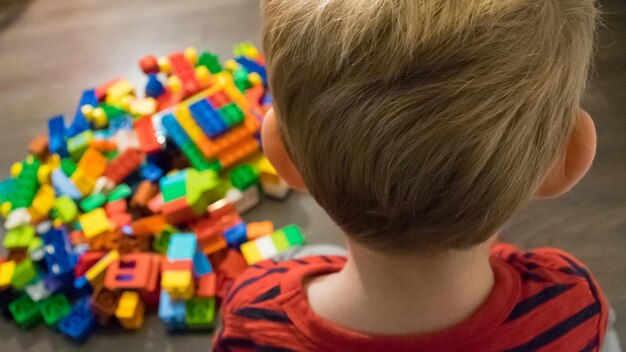 Foto achtergrondbeeld van een jongen die met speelgoedblokken staat