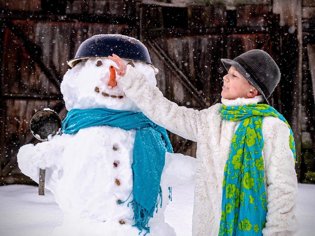 Achtergrondbeeld van een kind en een sneeuwman in de winter