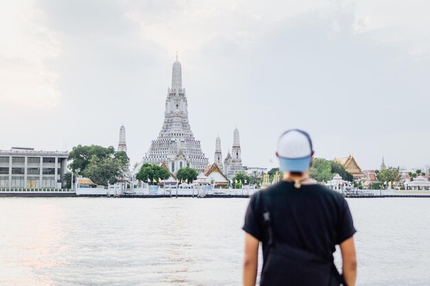 Foto achtergrondbeeld van een man die bij de rivier tegen de lucht staat