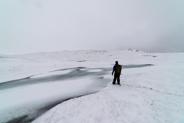 Achtergrondbeeld van een man die in de winter op een met sneeuw bedekt veld staat