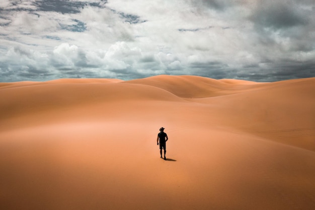 Foto achtergrondbeeld van een man die in de woestijn loopt