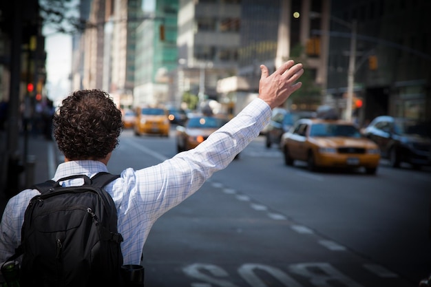 Achtergrondbeeld van een man die met zijn hand zwaait terwijl hij op een stadsstraat staat
