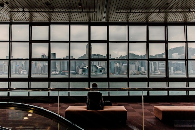 Achtergrondbeeld van een man die op een bank zit in het Hong Kong Museum of Art