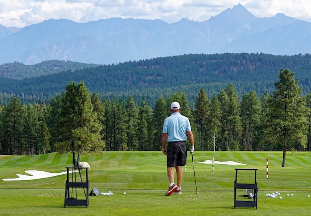 Foto achtergrondbeeld van een man die op een golfbaan loopt