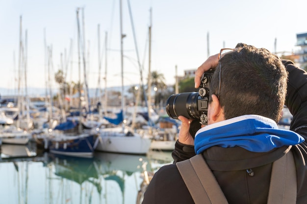 Achtergrondbeeld van een man die op een indiscreet manier foto's maakt met een professionele camera met een zoomlens